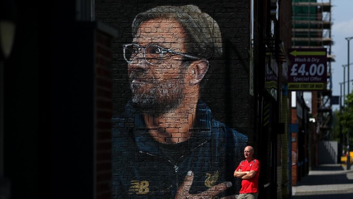 LIVERPOOL, ENGLAND - JUNE 26: A Fan poses next to Jurgen Klopp street art after Liverpool confirmed as Premier League Champions at Anfield on June 26, 2020 in Liverpool, England. Liverpool claim their first championship in 30 years. (Photo by Jan Kruger/Getty Images)