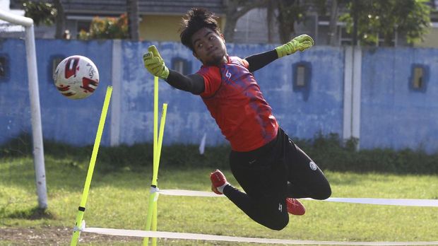 Penjaga gawang tim Arema FC, Kartika Aji berusaha menepis bola saat mengikuti latihan di lapangan Satsui Tubun, Malang, Jawa Timur, Kamis (25/6/2020). Latihan yang dilakukan di masa transisi normal baru tersebut hanya diikuti para pesepakbola yang berposisi sebagai penjaga gawang sementara pemain lainnya mengikuti latihan secara daring dari rumah. ANTARA FOTO/Ari Bowo Sucipto/aww.
