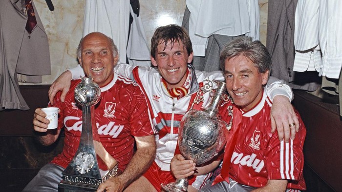 LIVERPOOL, ENGLAND - MAY 01: Liverpool Player/Manager Kenny Dalglish (c) on his final appearance as a player, Ronnie Moran (l) and Roy Evans celebrate the 1989/90 Division One Championship with the trophy in the changing room after a 1-0 win over Derby County at Anfield on May 1, 1990 in Liverpool, United Kingdom. (Photo by Dan Smith/Allsport/Getty Images/Hulton Archive)