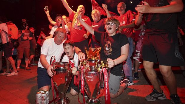 Liverpool supporters celebrate as they gather outside of Anfield Stadium in Liverpool, England, Friday, June 26, 2020 after Liverpool clinched the English Premier League title. Liverpool took the title after Manchester City failed to beat Chelsea on Wednesday evening. (AP photo/Jon Super)