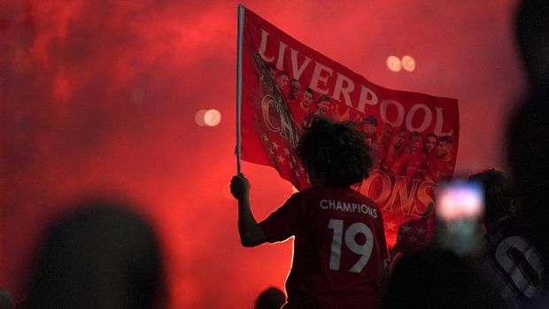 Liverpool supporters celebrate as they gather outside of Anfield Stadium in Liverpool, England, Friday, June 26, 2020 after Liverpool clinched the English Premier League title. Liverpool took the title after Manchester City failed to beat Chelsea on Wednesday evening. (AP photo/Jon Super)
