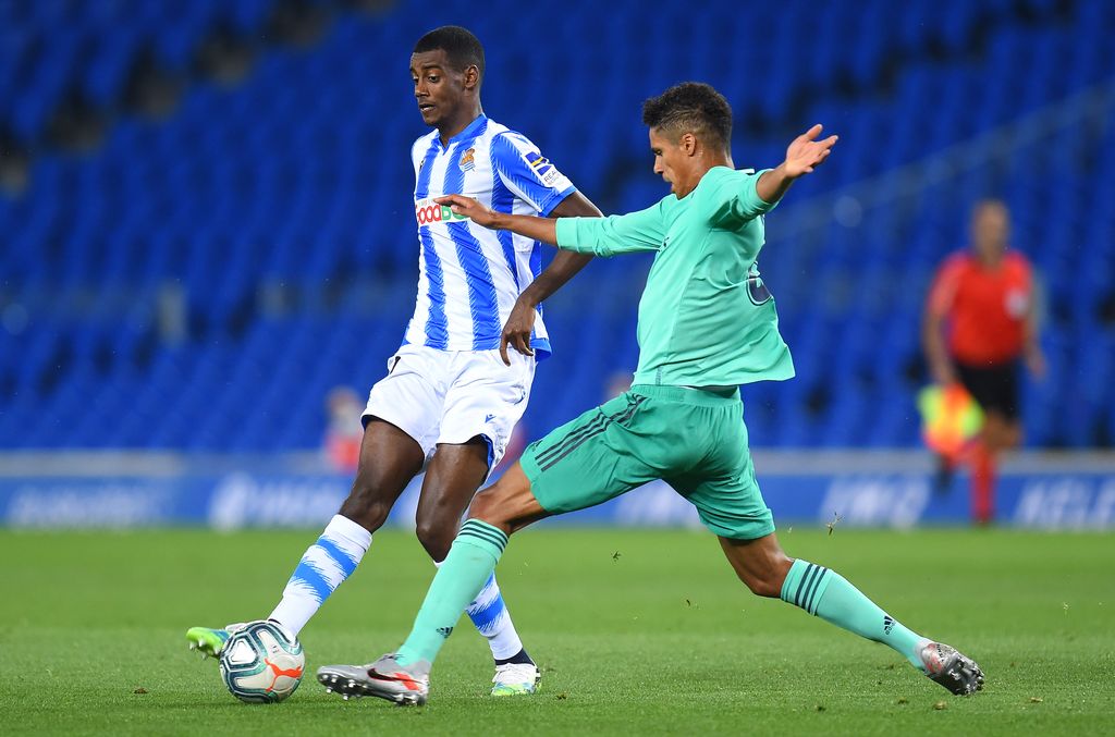 MADRID, SPAIN - JUNE 18:  Raphaël Varane of Real Madrid CF is fouled by Maximiliano Gómez of Valencia CF during the Liga match between Real Madrid CF and Valencia CF at Estadio Alfredo Di Stefano on June 18, 2020 in Madrid, Spain. (Photo by Denis Doyle/Getty Images)