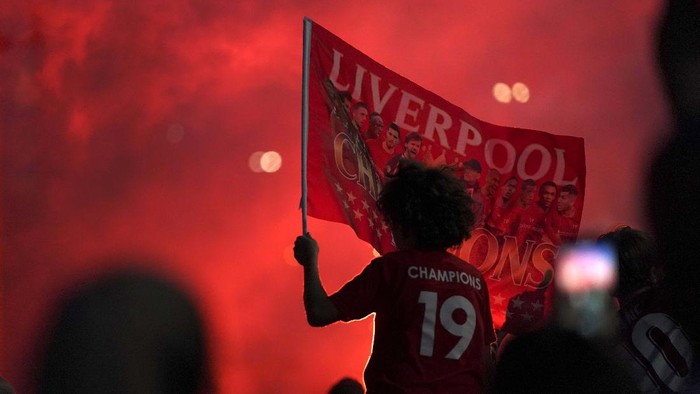 Liverpool supporters celebrate as they gather outside of Anfield Stadium in Liverpool, England, Thursday, June 25, 2020 after Liverpool clinched the English Premier League title. Liverpool took the title after Manchester City failed to beat Chelsea on Wednesday evening. (AP photo/Jon Super)