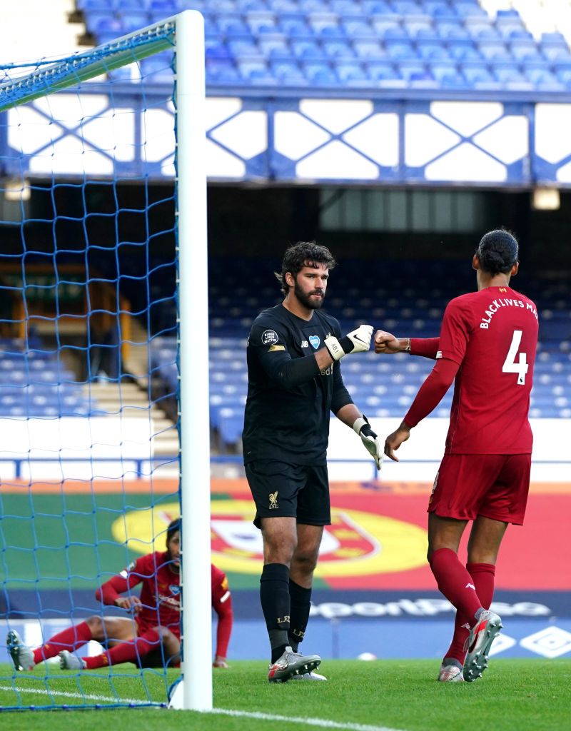LIVERPOOL, ENGLAND - JUNE 21: Alisson Becker of Liverpool interacts with Virgil van Dijk of Liverpool after he makes a save during the Premier League match between Everton FC and Liverpool FC at Goodison Park on June 21, 2020 in Liverpool, England. Football Stadiums around Europe remain empty due to the Coronavirus Pandemic as Government social distancing laws prohibit fans inside venues resulting in all fixtures being played behind closed doors. (Photo by Jon Super/Pool via Getty Images)