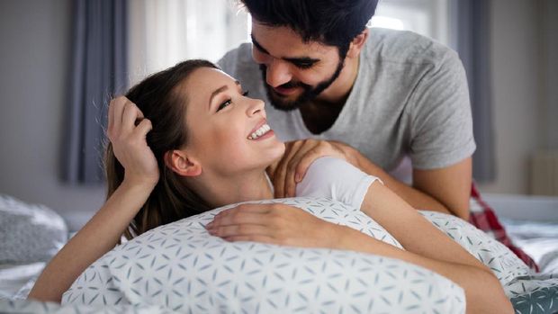 Cheerful young happy couple making massage at home