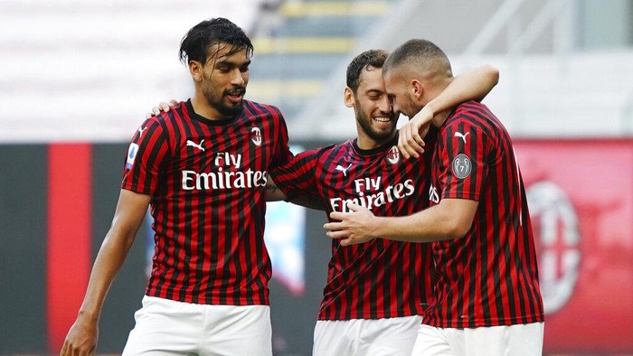 AC Milans Ante Rebic, right, celebrates with teammates Hakan Calhanoglu, center, and Lucas Paqueta after scoring his sides opening goal during the Serie A soccer match between AC Milan and Roma, at the San Siro Stadium in Milan, Sunday, June 28, 2020. (Spada/LaPresse via AP)