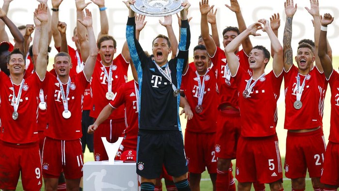 Munichs team captain Manuel Neuer lifts the trophy after  the German Bundesliga soccer match between VfL Wolfsburg and FC Bayern Munich in Wolfsburg, Germany, Saturday, June 27, 2020. Bayern wins the 8th straight Bundesliga title. (Kai Pfaffenbach/Pool Photo via AP)