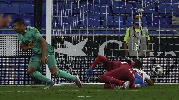 Real Madrids Casemiro, left, celebrates after scoring the opening goal during the Spanish La Liga soccer match between RCD Espanyol and Real Madrid at the Cornella-El Prat stadium in Barcelona, Spain, Sunday, June 28, 2020. (AP Photo/Joan Monfort)