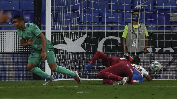 Real Madrid's Casemiro, left, celebrates after scoring the opening goal during the Spanish La Liga soccer match between RCD Espanyol and Real Madrid at the Cornella-El Prat stadium in Barcelona, Spain, Sunday, June 28, 2020. (AP Photo/Joan Monfort)