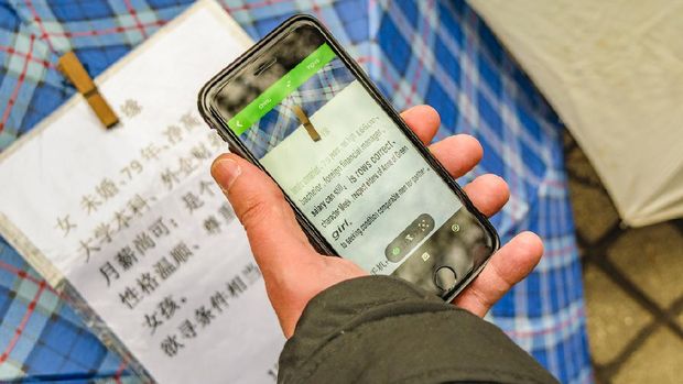 SHANGHAI, CHINA, DECEMBER - 2018 - Man using google translate to read chinese letters at people square, shanghai, china