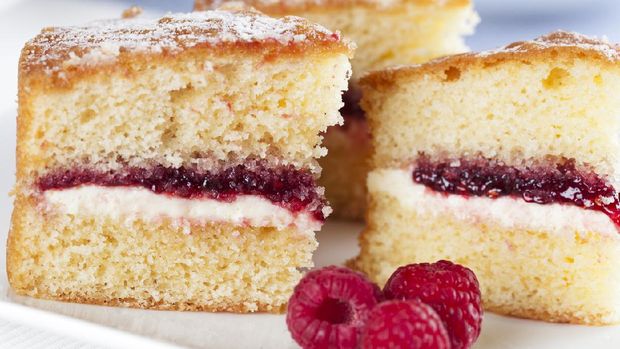 Victoria sponge cake with cream and jam filling, served with raspberries