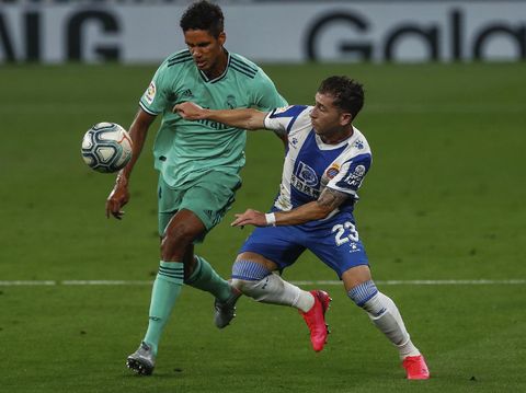 Real Madrid's Raphael Varane, left, duels for the ball against Espanyol's Adri Embarba during the Spanish La Liga soccer match between RCD Espanyol and Real Madrid at the Cornella-El Prat stadium in Barcelona, Spain, Sunday, June 28, 2020. (AP Photo/Joan Monfort)