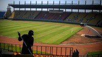 Seorang pekerja sedang membersihkan bangku penonton di Stadion Si Jalak Harupat yang berada di Soreang, Kabupaten Bandung, Jawa Barat, Senin (29/6/2020).