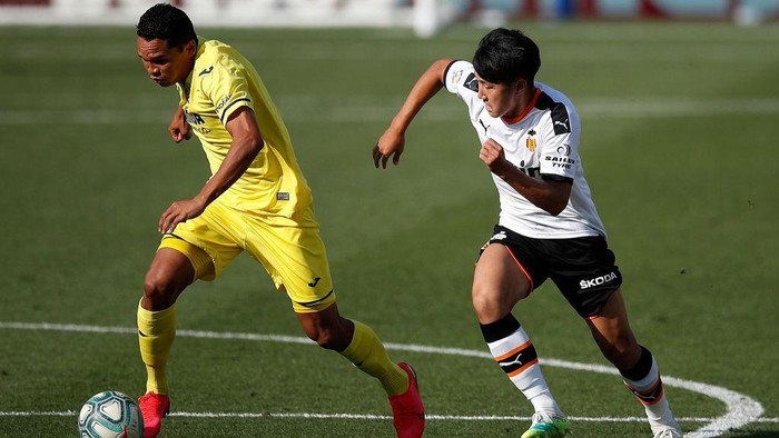 VILLAREAL, SPAIN - JUNE 28: Carlos Bacca (l) of Villareal is tracked by Lee Kang-In of Valencia during the Liga match between Villarreal CF and Valencia CF at Estadio de la Ceramica on June 28, 2020 in Villareal, Spain. (Photo by Eric Alonso/Getty Images)