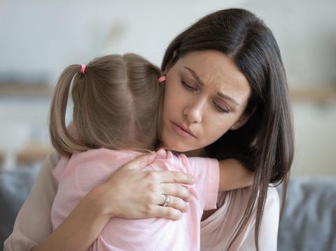 Worried young foster care parent mother comforting solacing embrace adopted little child daughter give care and protection at home, loving concerned adult mom hug sad small girl consoling kid concept