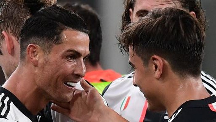 Juventus Portuguese forward Cristiano Ronaldo (L) celebrates with Juventus Argentine forward Paulo Dybala after scoring during the Italian Serie A football match Genoa vs Juventus played on June 30, 2020 behind closed doors at the Luigi-Ferraris stadium in Genoa, as the country eases its lockdown aimed at curbing the spread of the COVID-19 infection, caused by the novel coronavirus. (Photo by Miguel MEDINA / AFP)
