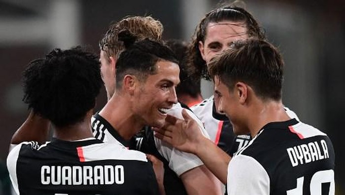 Juventus Portuguese forward Cristiano Ronaldo celebrates with Juventus Argentine forward Paulo Dybala after scoring during the Italian Serie A football match Genoa vs Juventus played on June 30, 2020 behind closed doors at the Luigi-Ferraris stadium in Genoa, as the country eases its lockdown aimed at curbing the spread of the COVID-19 infection, caused by the novel coronavirus. (Photo by Miguel MEDINA / AFP)