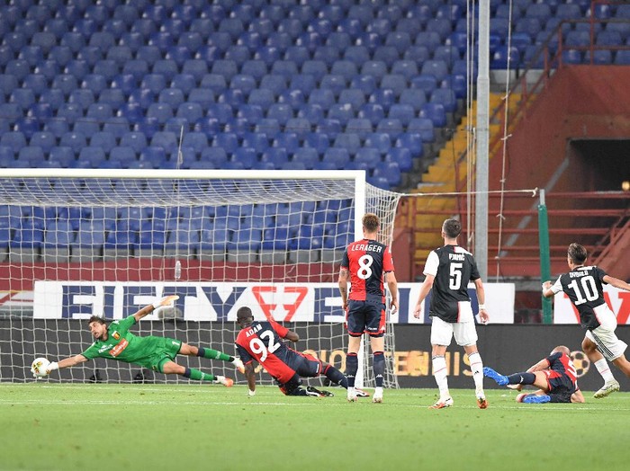 Juventus' Juan Cuadrado, right, in action during an Italian Serie A soccer match between Genoa and Juventus at the Luigi Ferraris stadium in Genoa, Italy, Tuesday, June 30, 2020. (Tano Pecoraro/LaPresse via AP)