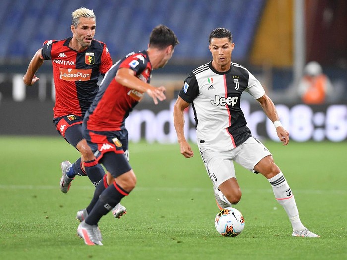 Juventus' Juan Cuadrado, right, in action during an Italian Serie A soccer match between Genoa and Juventus at the Luigi Ferraris stadium in Genoa, Italy, Tuesday, June 30, 2020. (Tano Pecoraro/LaPresse via AP)