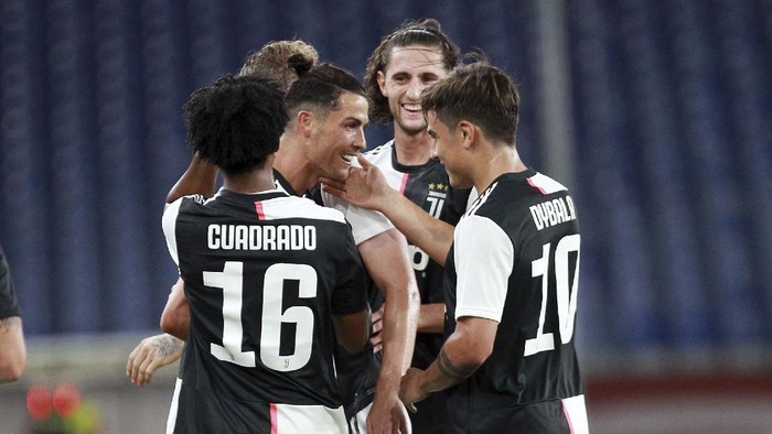 Juventus Juan Cuadrado, right, in action during an Italian Serie A soccer match between Genoa and Juventus at the Luigi Ferraris stadium in Genoa, Italy, Tuesday, June 30, 2020. (Tano Pecoraro/LaPresse via AP)