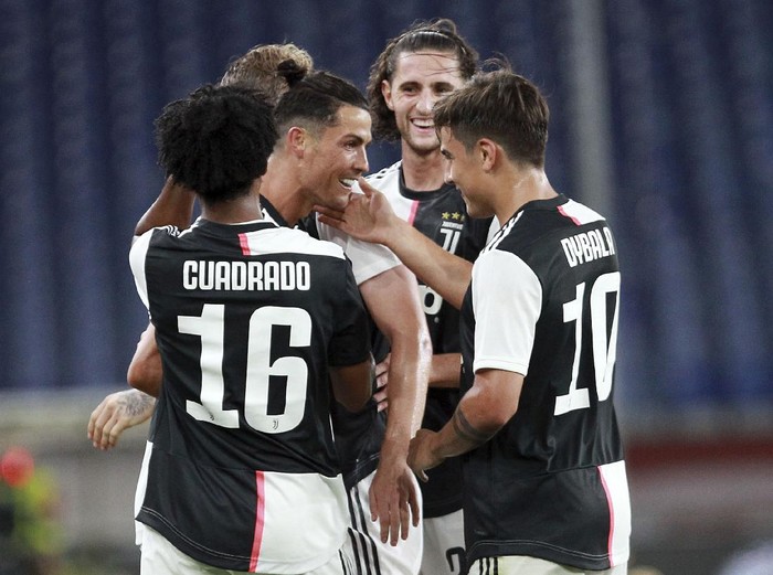 Juventus' Juan Cuadrado, right, in action during an Italian Serie A soccer match between Genoa and Juventus at the Luigi Ferraris stadium in Genoa, Italy, Tuesday, June 30, 2020. (Tano Pecoraro/LaPresse via AP)