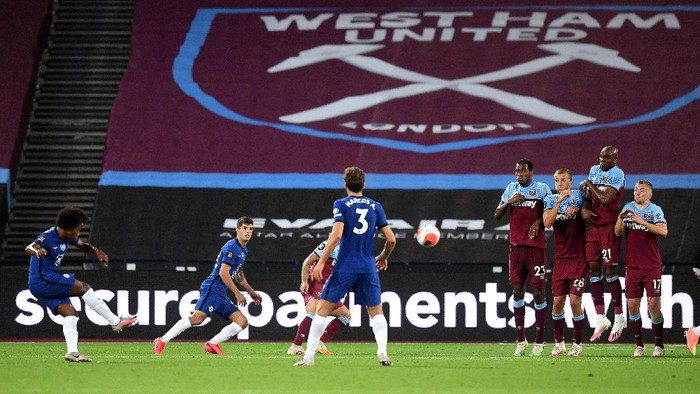 LONDON, ENGLAND - JULY 01: Willian of Chelsea scores his teams second goal from a free kick during the Premier League match between West Ham United and Chelsea FC at London Stadium on July 01, 2020 in London, England. Football Stadiums around Europe remain empty due to the Coronavirus Pandemic as Government social distancing laws prohibit fans inside venues resulting in all fixtures being played behind closed doors. (Photo by Michael Regan/Getty Images)