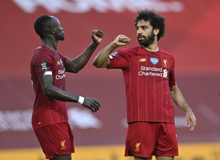 Liverpools Mohamed Salah, right, celebrates after scoring the second goal with Sadio Mane during the English Premier League soccer match between Liverpool and Crystal Palace at Anfield Stadium in Liverpool, England, Wednesday, June 24, 2020. (Paul Ellis/Pool via AP)