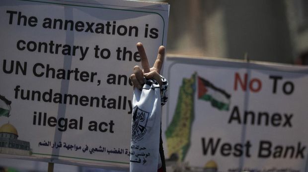 A Palestinian woman flashes the victory sign as she demonstrates against Israeli plans for the annexation of parts of the West Bank, in Gaza City, Wednesday, July 1, 2020. (AP Photo/Khalil Hamra)