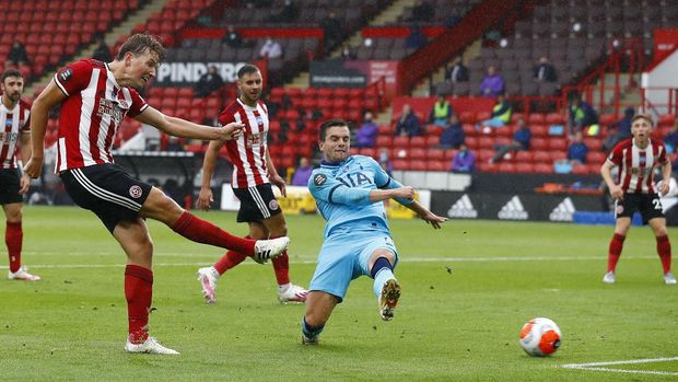 Sheffield United's Sander Berge, left, scores the opening goal of his team during the English Premier League soccer match between Sheffield United and Tottenham Hotspur at Bramall Lane in Sheffield, England, Thursday, July 2, 2020. (Jason Cairnduff/Pool via AP)