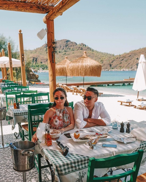 Nikita dan Indra berkunjung ke resor wisata terkenal di Mugla, Turki. Keduanya makan siang dengan latar belakang pemandangan laut yang cantik.