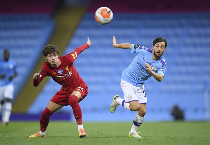 Manchester Citys Bernardo Silva, right, and Liverpools Neco Williams battle for the ball during the English Premier League soccer match between Manchester City and Liverpool at Etihad Stadium in Manchester, England, Thursday, July 2, 2020. (AP Photo/Laurence Griffiths,Pool)