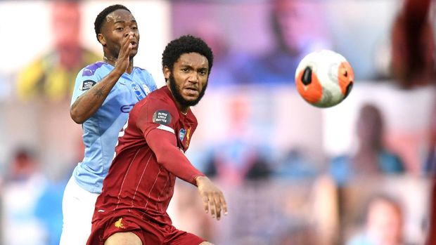 Manchester City's Raheem Sterling, left, and Liverpool's Joe Gomez battle for the ball during the English Premier League soccer match between Manchester City and Liverpool at Etihad Stadium in Manchester, England, Thursday, July 2, 2020. (AP Photo/Peter Powell,Pool)