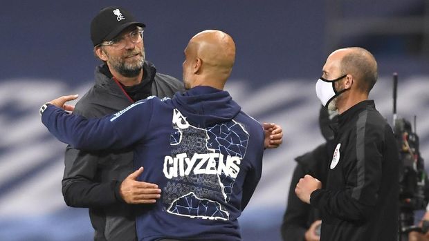 Liverpool's manager Jurgen Klopp, left, and Manchester City's head coach Pep Guardiola embrace after the English Premier League soccer match between Manchester City and Liverpool at Etihad Stadium in Manchester, England, Thursday, July 2, 2020. (AP Photo/Laurence Griffiths,Pool)