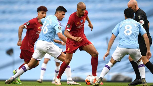 MANCHESTER, ENGLAND - JULY 02: Fabinho of Liverpool is challenged by Rodrigo and Ilkay Gundogan of Manchester City during the Premier League match between Manchester City and Liverpool FC at Etihad Stadium on July 02, 2020 in Manchester, England. Football Stadiums around Europe remain empty due to the Coronavirus Pandemic as Government social distancing laws prohibit fans inside venues resulting in all fixtures being played behind closed doors. (Photo by Peter Powell/Pool via Getty Images)