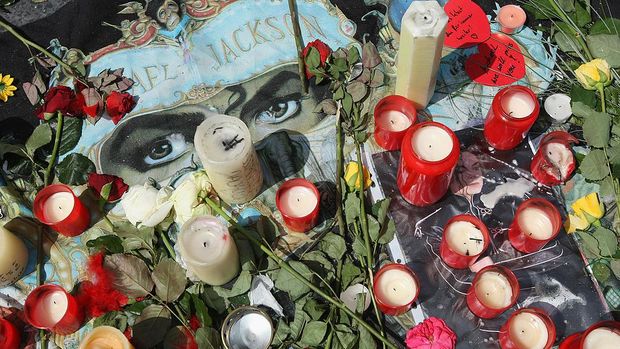 SYDNEY, AUSTRALIA - JUNE 26: Michael Jackson impersonator Jason Jackson lays a carnation at the memorial plaque during a memorial service commemorating the first anniversary of his death at Forest Lawn Memorial Park on June 26, 2010 in Sydney, Australia. Fans across the globe marked the passing of Jackson in a simultaneous 'World Cry' tribute hosted in various cities including New York, London and Paris.  (Photo by Brendon Thorne/Getty Images)