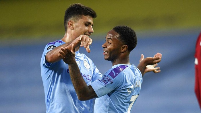 Manchester Citys Raheem Sterling is congratulated by teammate Rodrigo during the English Premier League soccer match between Manchester City and Liverpool at Etihad Stadium in Manchester, England, Thursday, July 2, 2020. (AP Photo/Peter Powell,Pool)