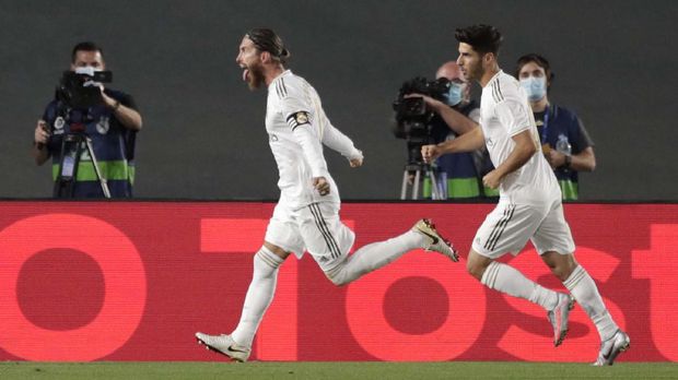 Real Madrid's Sergio Ramos, left, celebrates after scoring his side's opening goal from a penalty shot during the Spanish La Liga soccer match between Real Madrid and Getafe at the Alfredo di Stefano stadium in Madrid, Spain, Thursday, July 2, 2020. (AP Photo/Bernat Armangue)