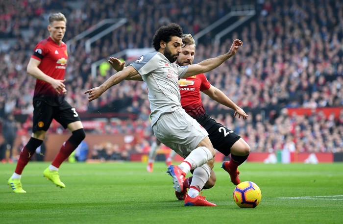 MANCHESTER, ENGLAND - FEBRUARY 24:  Mohamed Salah of Liverpool crosses the ball under pressure from Luke Shaw of Manchester United during the Premier League match between Manchester United and Liverpool FC at Old Trafford on February 24, 2019 in Manchester, United Kingdom.  (Photo by Laurence Griffiths/Getty Images)