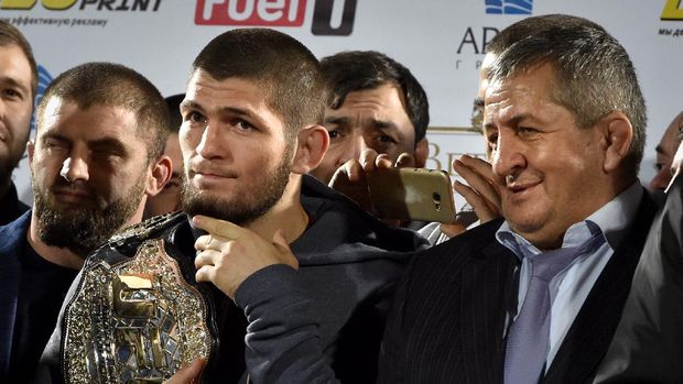 UFC lightweight champion Khabib Nurmagomedov (L) of Russia holds his champions belt next to his father Abdulmanap (C) during a ceremony upon the arrival at the Anzhi-arena stadium in Makhachkala on October 8, 2018. - He defeated Conor McGregor of Ireland in their UFC lightweight championship bout by way of submission during the UFC 229 event inside T-Mobile Arena on October 6, 2018 in Las Vegas, Nevada. (Photo by Vasily MAXIMOV / AFP)