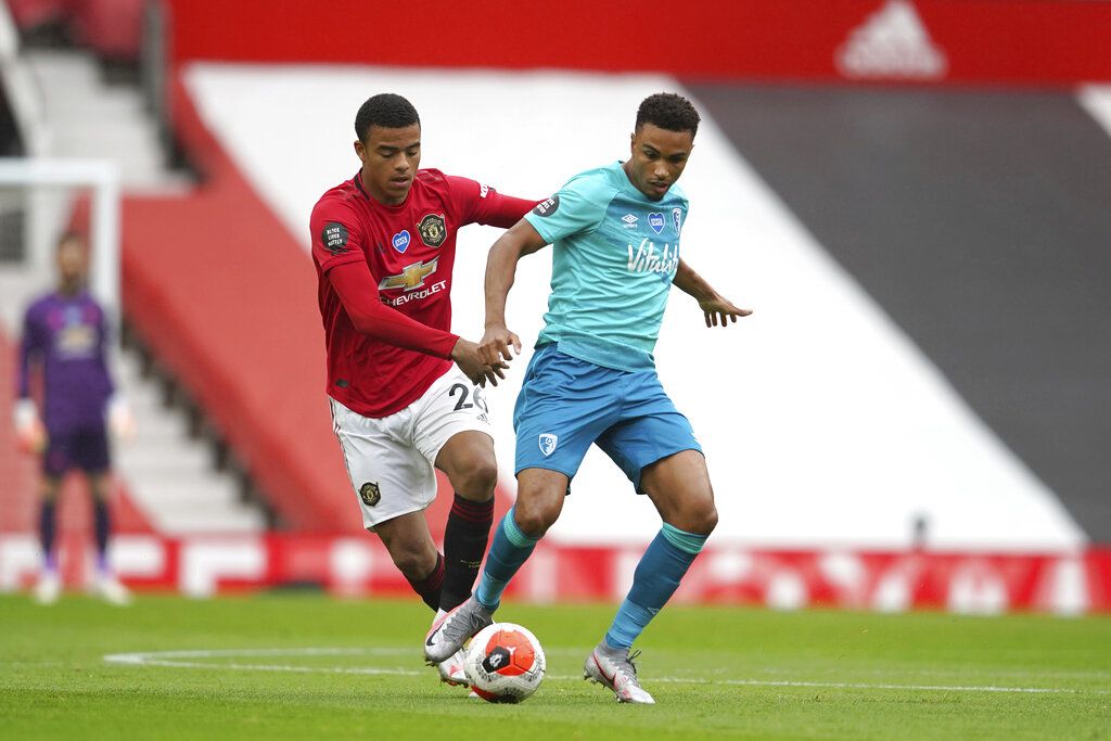 Manchester United's Mason Greenwood, left, and Bournemouth's Junior Stanislas compete for the ball during the English Premier League soccer match between Manchester United and Bournemouth at Old Trafford stadium in Manchester, England, Saturday, July 4, 2020. (AP Photo/Dave Thompson, Pool)