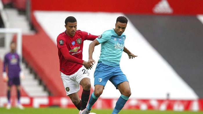 Manchester Uniteds Mason Greenwood, left, and Bournemouths Junior Stanislas compete for the ball during the English Premier League soccer match between Manchester United and Bournemouth at Old Trafford stadium in Manchester, England, Saturday, July 4, 2020. (AP Photo/Dave Thompson, Pool)