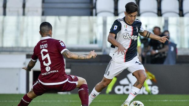 Juventus' Paulo Dybala, right, dribbles past Torino's Armando Izzo during the Serie A soccer match between Juventus and Torino, at the Allianz Stadium in Turin, Italy, Saturday, July 4, 2020. (Marco Alpozzi/LaPresse via AP)