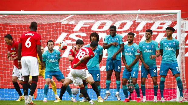 Manchester United's Bruno Fernandes (18) shoots a goal-scoring free kick during the English Premier League soccer match between Manchester United and Bournemouth at Old Trafford stadium in Manchester, England, Saturday, July 4, 2020. (Clive Brunskill/Pool via AP)
