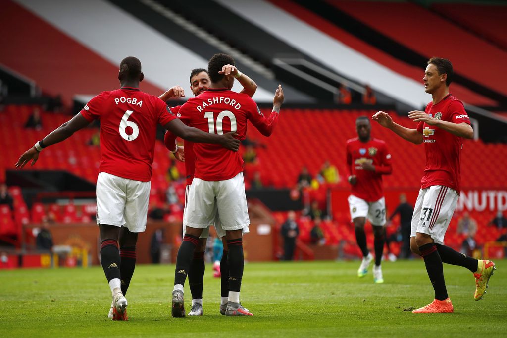 MANCHESTER, ENGLAND - JULY 04: Mason Greenwood of Manchester United celebrates with teammates Paul Pogba, Bruno Fernandes and Nemanja Matic of Manchester United after scoring his team's second goal from the penalty spot during the Premier League match between Manchester United and AFC Bournemouth  at Old Trafford on July 04, 2020 in Manchester, England. Football Stadiums around Europe remain empty due to the Coronavirus Pandemic as Government social distancing laws prohibit fans inside venues resulting in all fixtures being played behind closed doors. (Photo by Clive Brunskill/Getty Images)