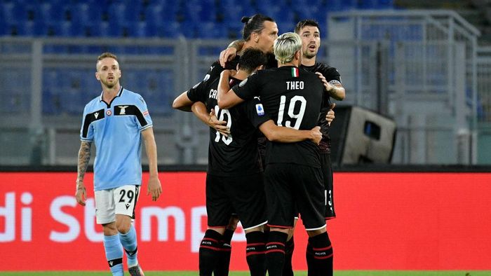 1254285762 ROME, ITALY - JULY 04: Hakan Calhanoglu of AC Milan celebrates after scoring the opening goal with teammates during the Serie A match between SS Lazio and AC Milan at Stadio Olimpico on July 04, 2020 in Rome, Italy. (Photo by Marco Rosi - SS Lazio/Getty Images)