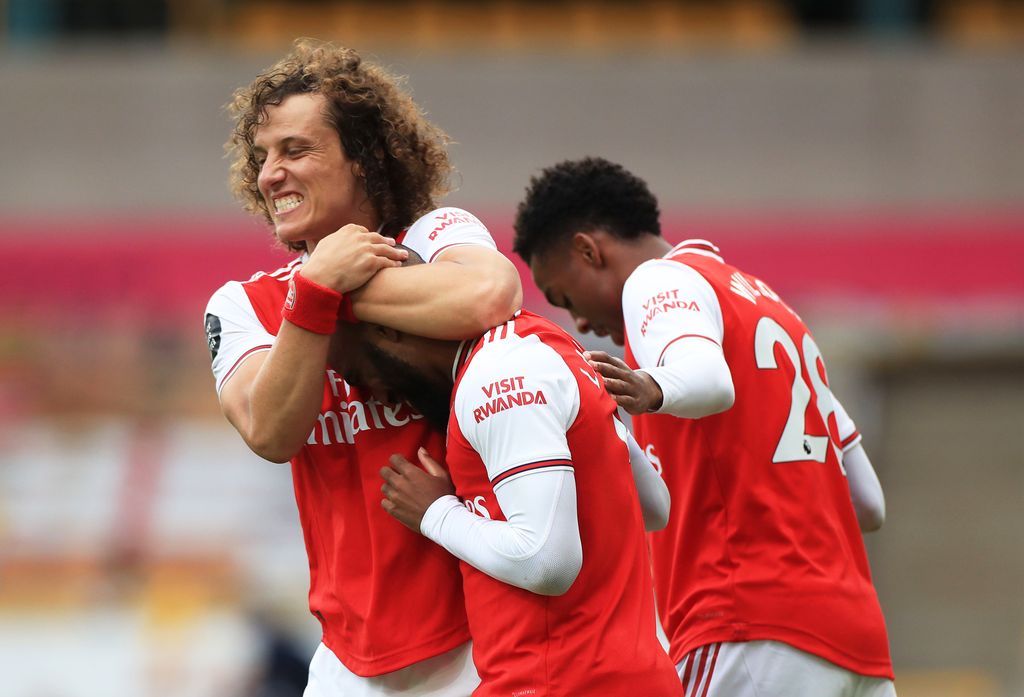 WOLVERHAMPTON, ENGLAND - JULY 04: Alexandre Lacazette of Arsenal celebrates with teammate David Luiz after scoring his team's second goal during the Premier League match between Wolverhampton Wanderers and Arsenal FC at Molineux on July 04, 2020 in Wolverhampton, England. Football Stadiums around Europe remain empty due to the Coronavirus Pandemic as Government social distancing laws prohibit fans inside venues resulting in all fixtures being played behind closed doors. (Photo by Mike Egerton/Pool via Getty Images)