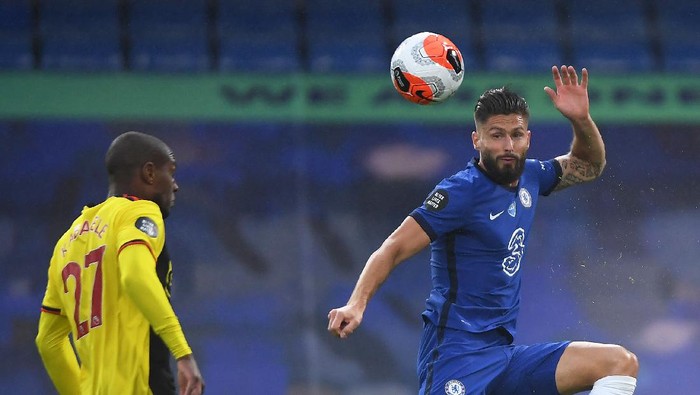 LONDON, ENGLAND - JULY 04: Olivier Giroud of Chelsea jumps for the ball under pressure from Christian Kabasele of Watford during the Premier League match between Chelsea FC and Watford FC at Stamford Bridge on July 04, 2020 in London, England. Football Stadiums around Europe remain empty due to the Coronavirus Pandemic as Government social distancing laws prohibit fans inside venues resulting in all fixtures being played behind closed doors. (Photo by Mike Hewitt/Getty Images)