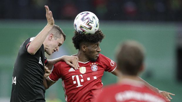 Leverkusen's Sven Bender, left, jumps for a header with Bayern's Kingsley Coman during the German soccer cup (DFB Pokal) final match between Bayer 04 Leverkusen and FC Bayern Munich in Berlin, Germany, Saturday, July 4, 2020. (AP Photo/Michael Sohn)