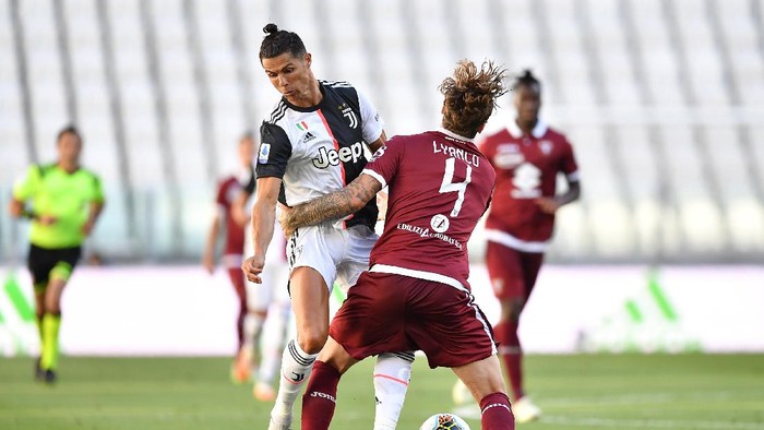 TURIN, ITALY - JULY 04:  Cristiano Ronaldo (L) of Juventus is tackled by Vojnovic Lyanco of Torino FC during the Serie A match between Juventus and Torino FC at Allianz Stadium on July 4, 2020 in Turin, Italy.  (Photo by Valerio Pennicino/Getty Images )