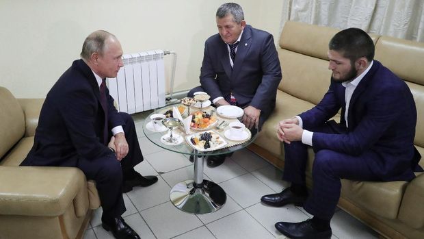 Russian President Vladimir Putin (L) speaks with UFC lightweight champion Khabib Nurmagomedov (R) and his father Abdulmanap (C) during their meeting at the Russia is a Sport State forum in Ulyanovsk on October 10, 2018. - Unbeaten Khabib Nurmagomedov will not be stripped of his UFC lightweight title despite his role in a post-match brawl Saturday, UFC president Dana White said in a website posting October 10, 2018. (Photo by Mikhail KLIMENTYEV / SPUTNIK / AFP)